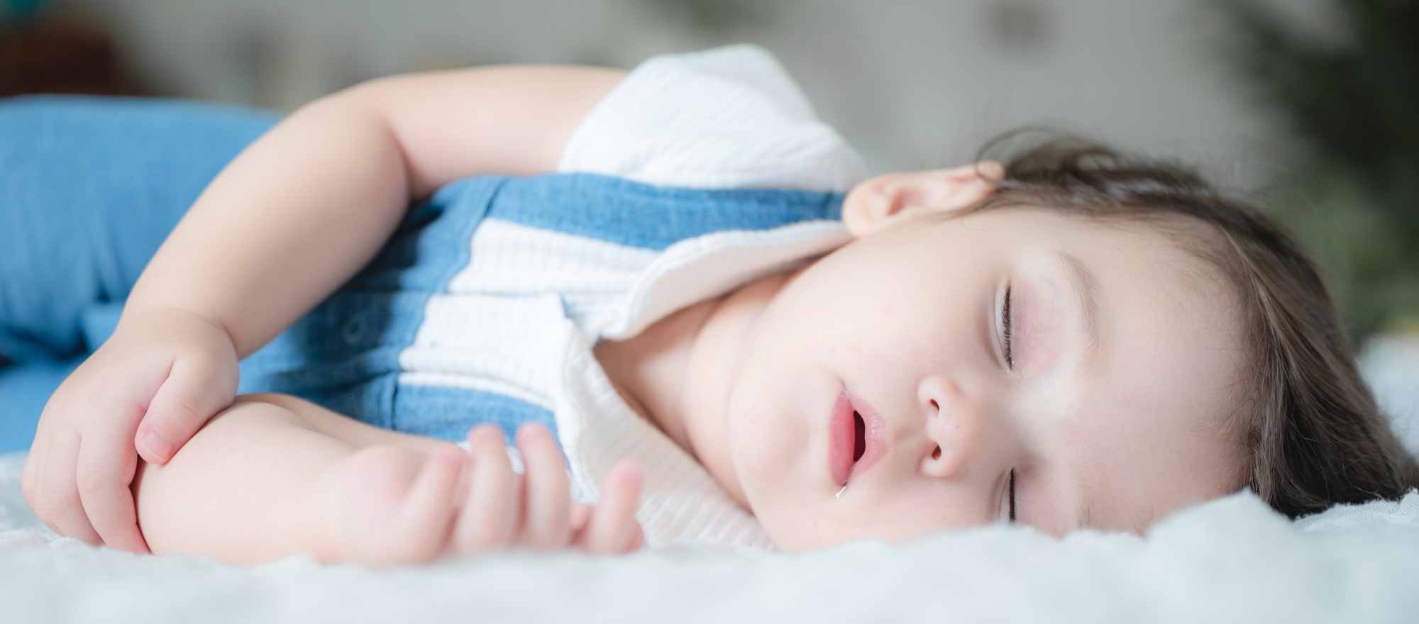 baby are sleeping on white bed at home